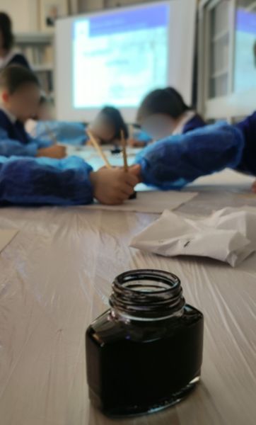 studenti scrivono con penna e calamaio